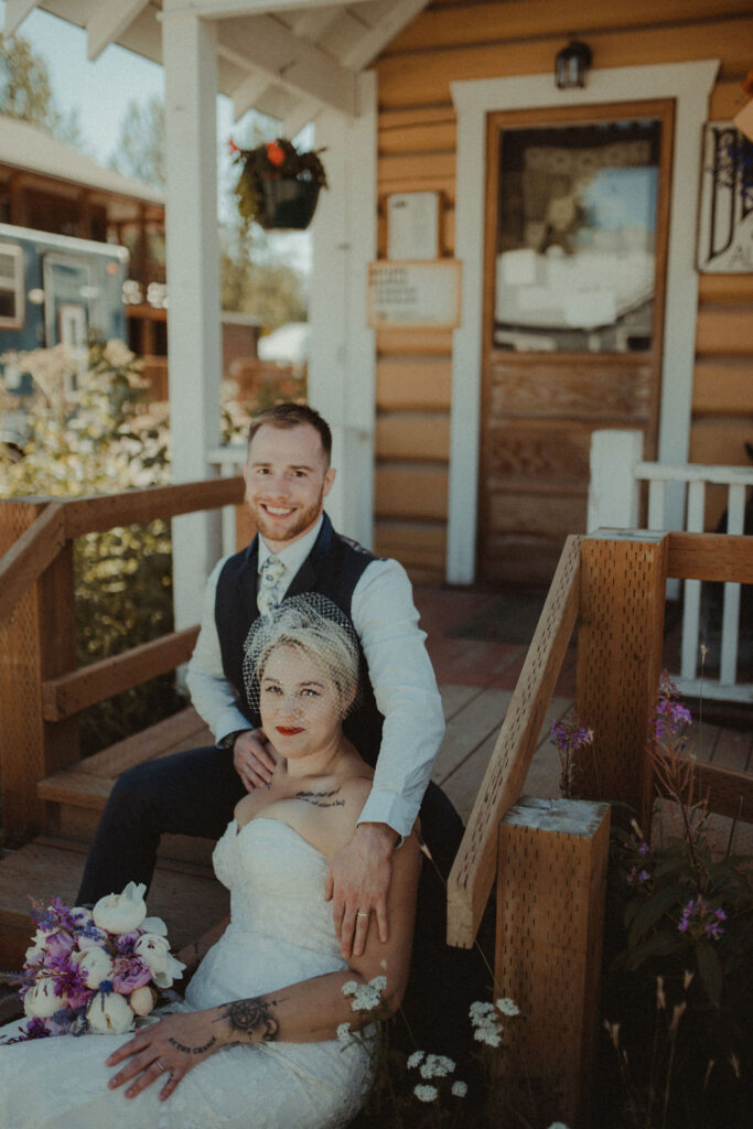 bride and groom sitting on porch during wedding day