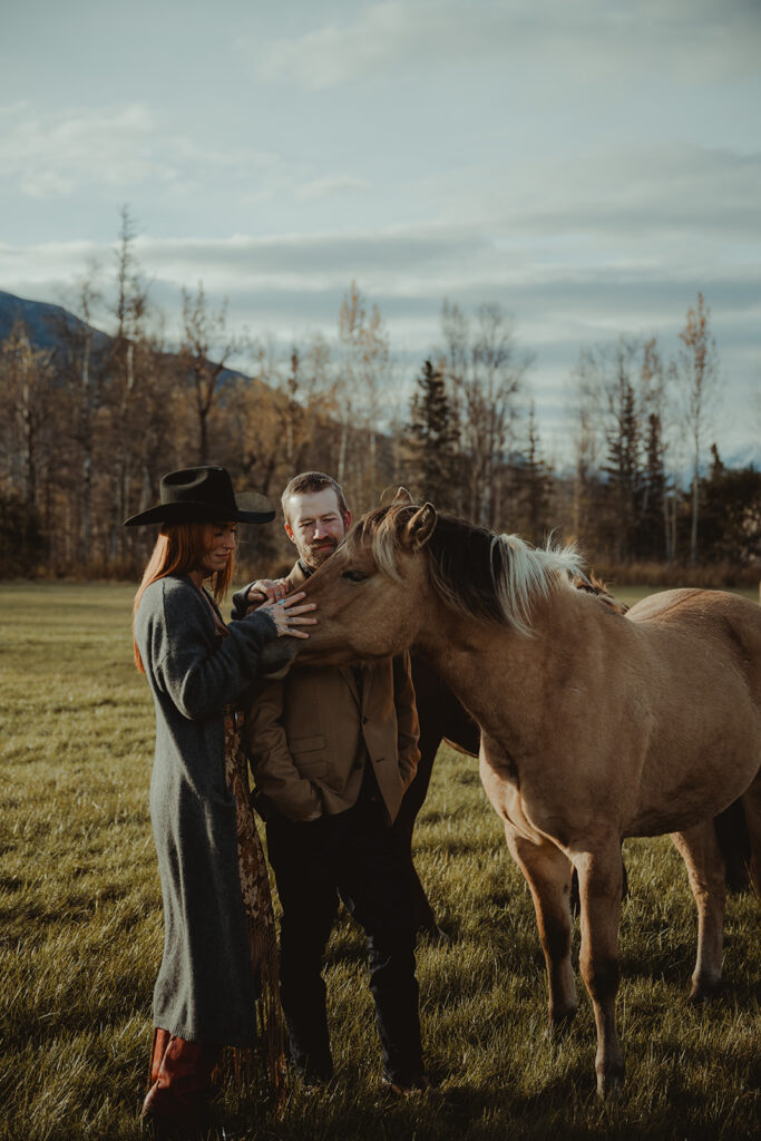 couple petting some horses at the ranch