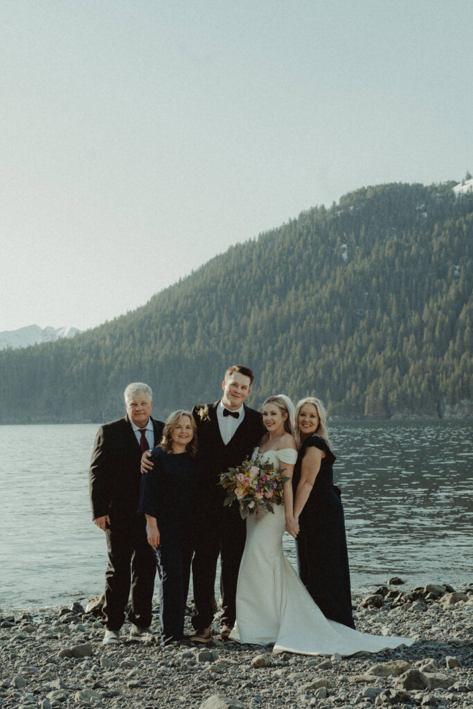 Family poses on a remote beach off the coast of prince william sound