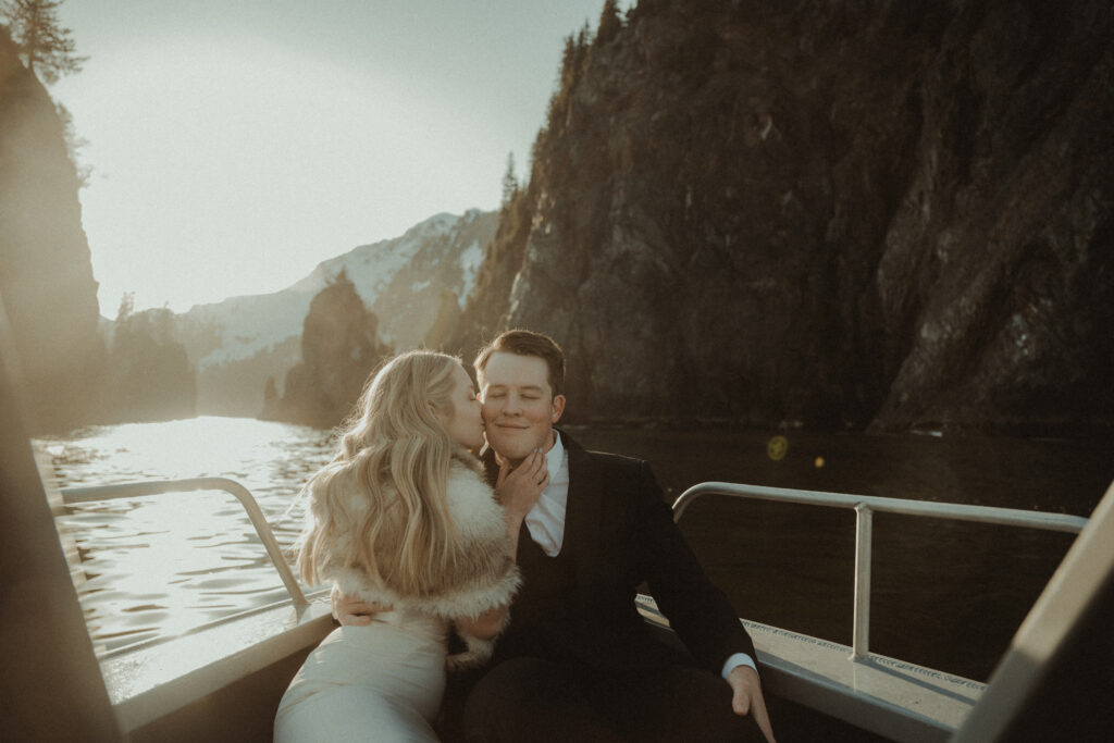 bride and groom enjoy the sunset on a private boat in alaska