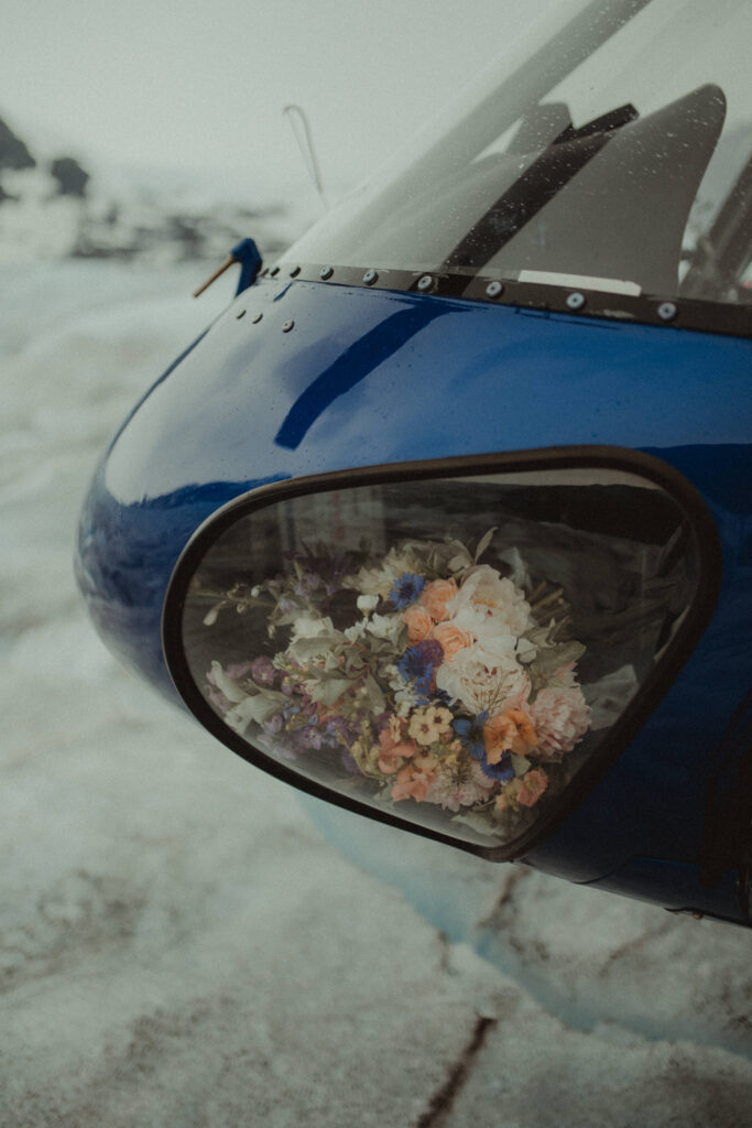 Alaska helicopter elopement photo of a helicopter with a bouquet of flowers