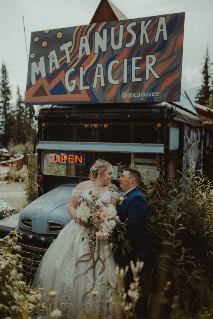 Wedding couple sit on an old bus at matanuska glacier