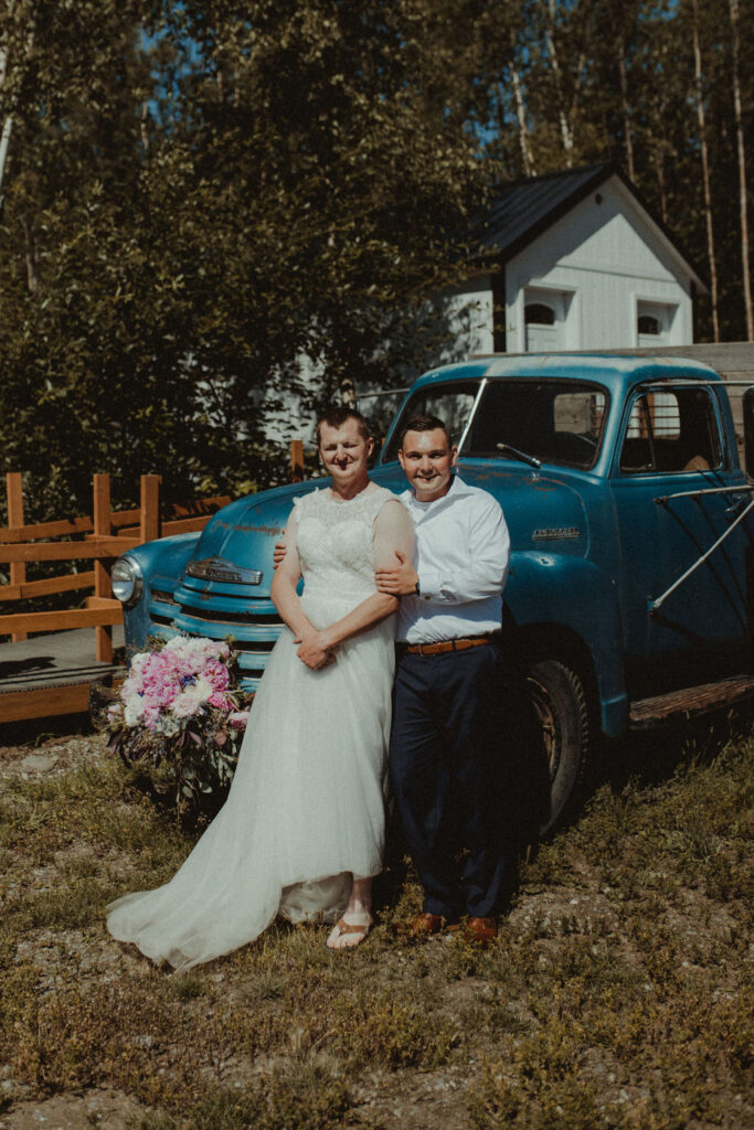 groom and groomsman sitting on a vintage truck