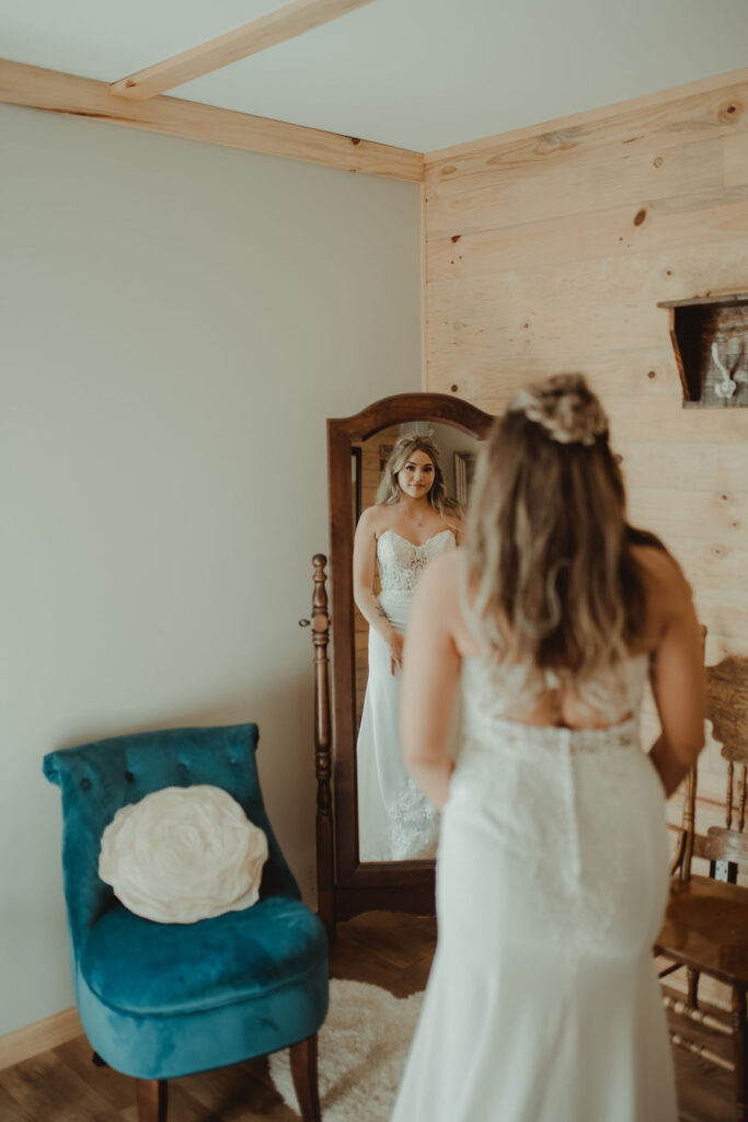 bride looking in the mirror before her rustic modern wedding ceremony