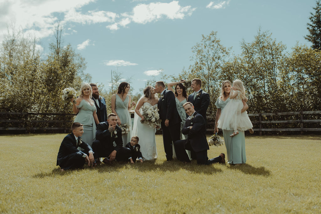 bride and groom with their bridesmaids and groomsmen at the rustic modern wedding