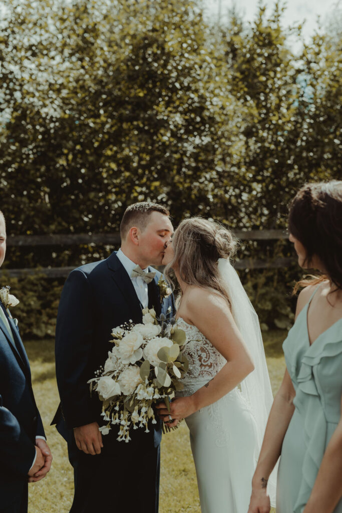 bride and groom kissing after their rustic modern wedding