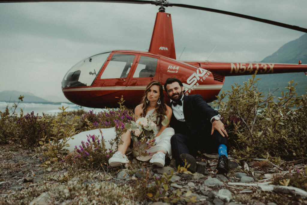 unique elopement photos with bride and groom in front of helicopter