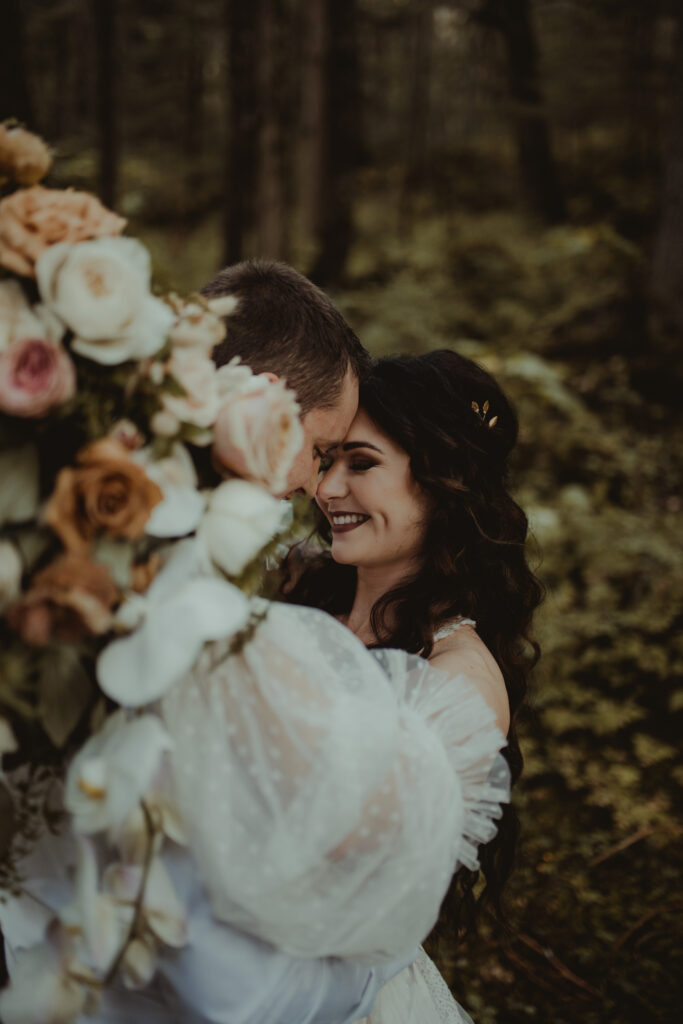 bride and groom embrace in a forest in girdwood
