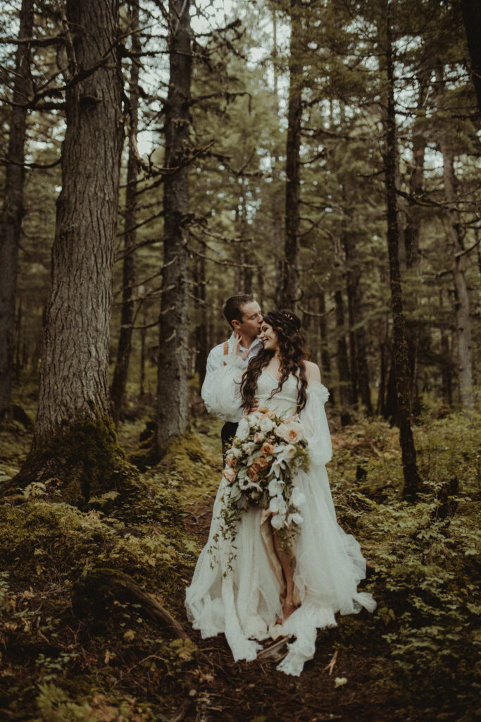 Bride and groom pose in a forest