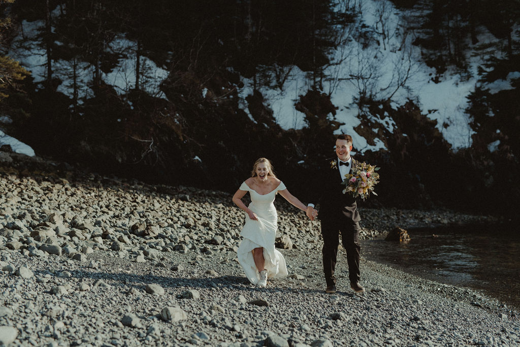 couple running during their alaska elopement photoshoot