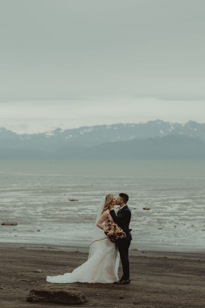 bride and groom kissing at the beach - planning your destination wedding