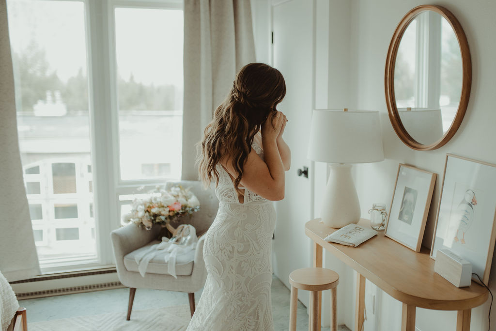 bride putting on her jewelry before the wedding ceremony