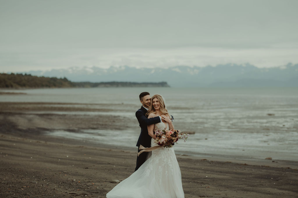 bride and groom hugging at the beach