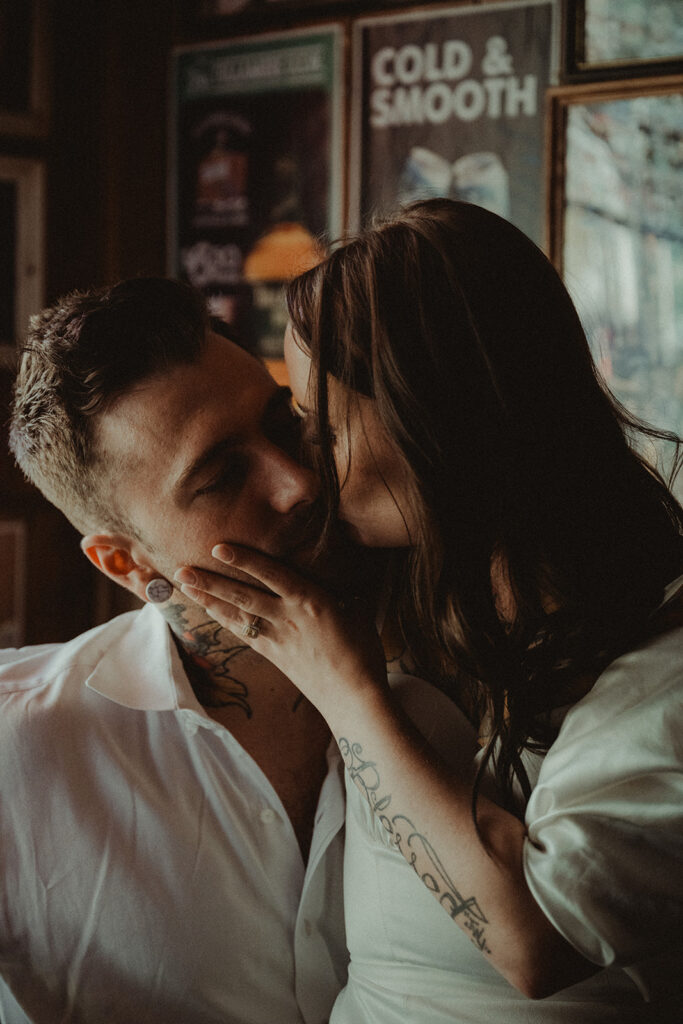 bride and groom kissing at the bar