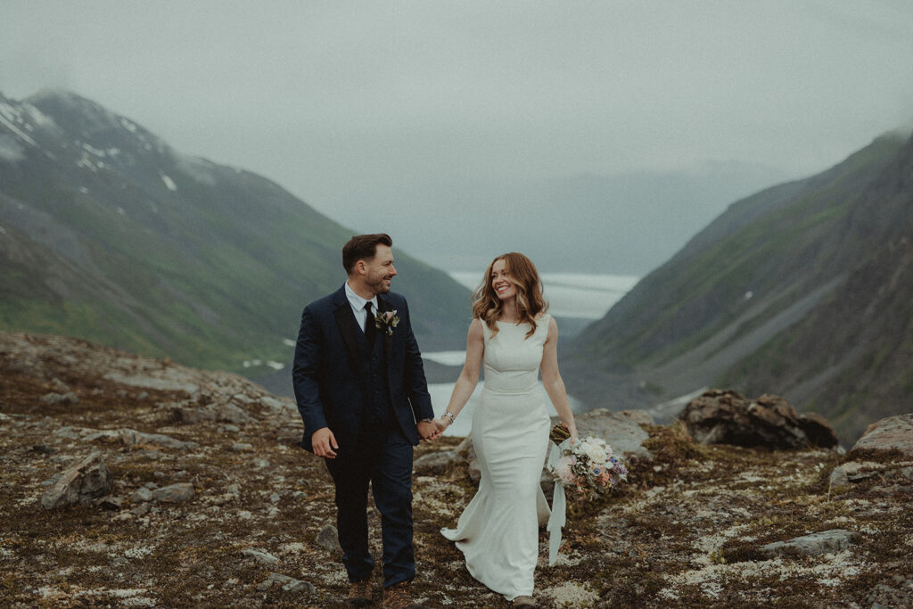 bride and groom holding hands looking at each other