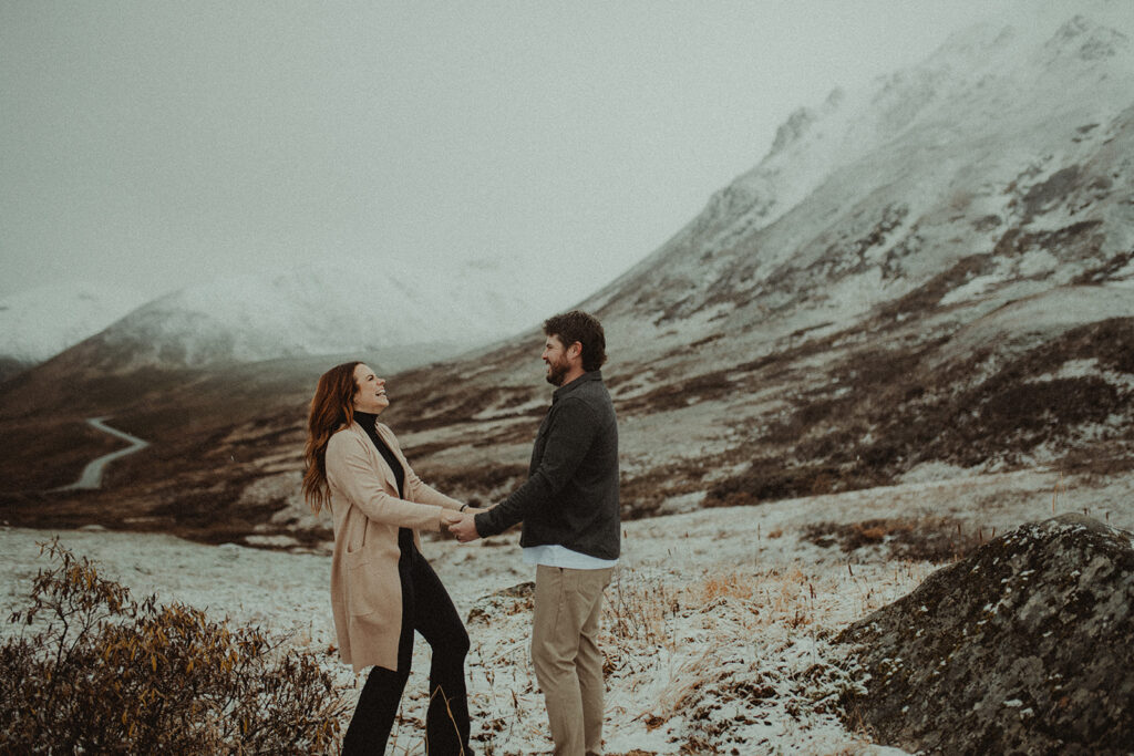 couple holding hands laughing with each other 