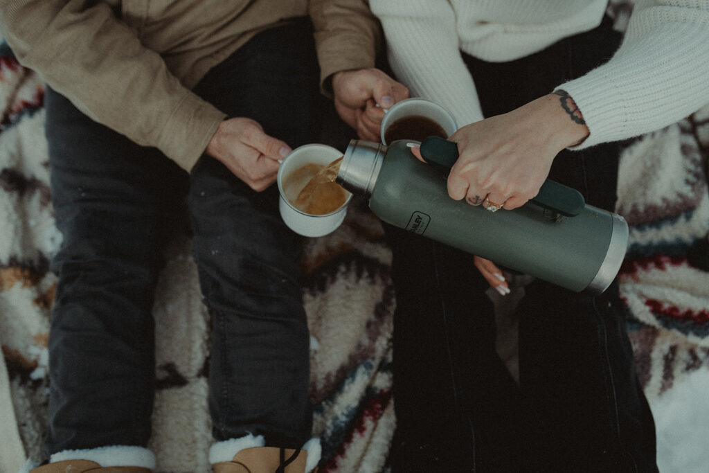 couple drinking tea at their Magical Winter Engagement Session at Knik Glacier