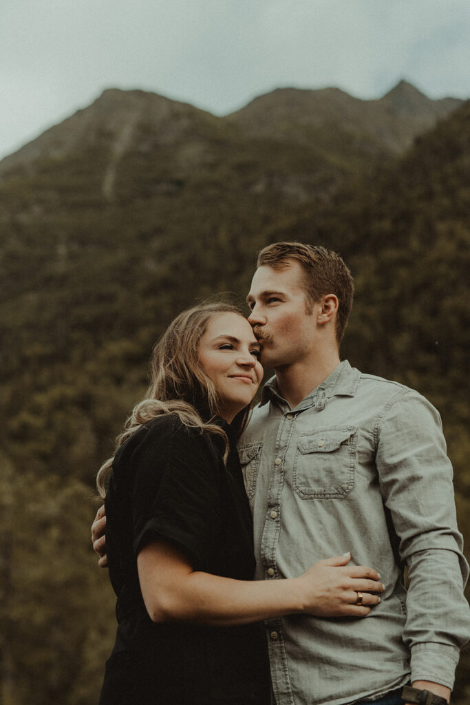 husband kissing his wife on the forehead 