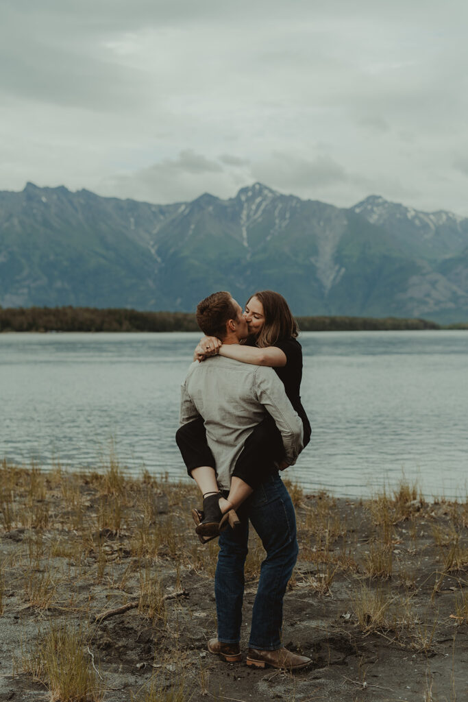 husband and wife kissing during their family photoshoot 