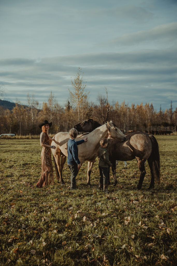 family petting horses at the ranch 