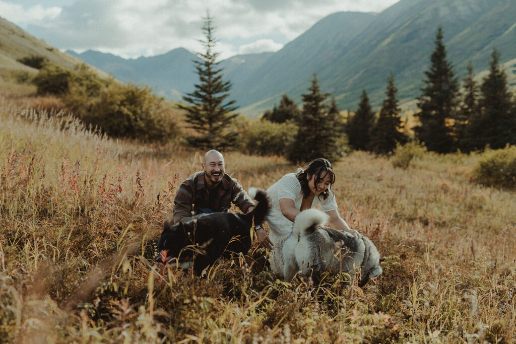 couple playing with their dogs during their engagement session