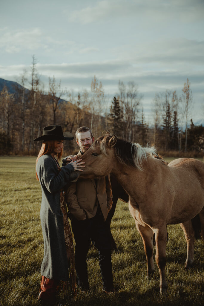 couple petting some horses at the ranch 